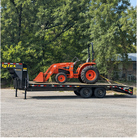 Compact tractor secured on a gooseneck trailer for equipment transport in Texas